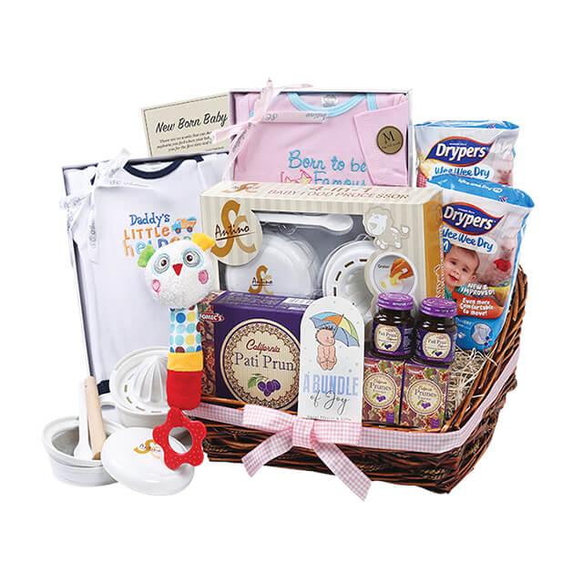 Newborn baby hamper with clothes, plush toy, prunes, and gift items for flower delivery.