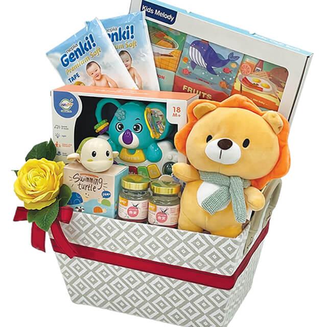 Flower delivery gift basket with yellow rose, baby toys, plush lion, and baby products.