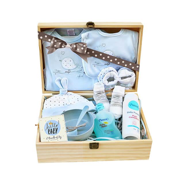 Baby clothing and bath essentials hamper in a wooden box, ideal for new baby flower delivery gift.