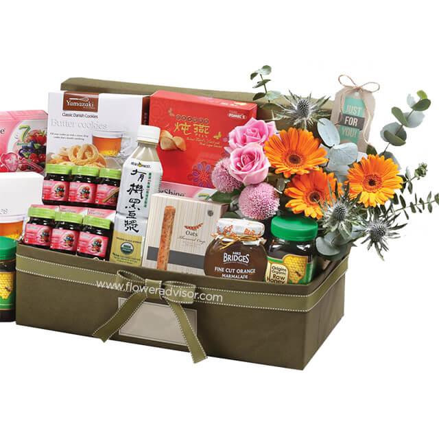 Flower delivery hamper with fresh roses, gerberas, and assorted gourmet treats in gift box
