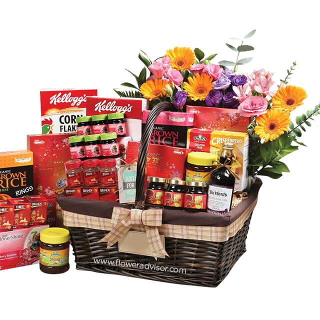 Flower delivery hamper with assorted groceries, fresh mixed flowers, and vibrant gift basket