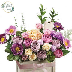 Artificial flower arrangement with mixed pastel roses and blooms in wooden box for delivery