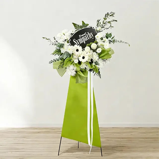 Sympathy funeral flower stand with white blooms and greenery for flower delivery