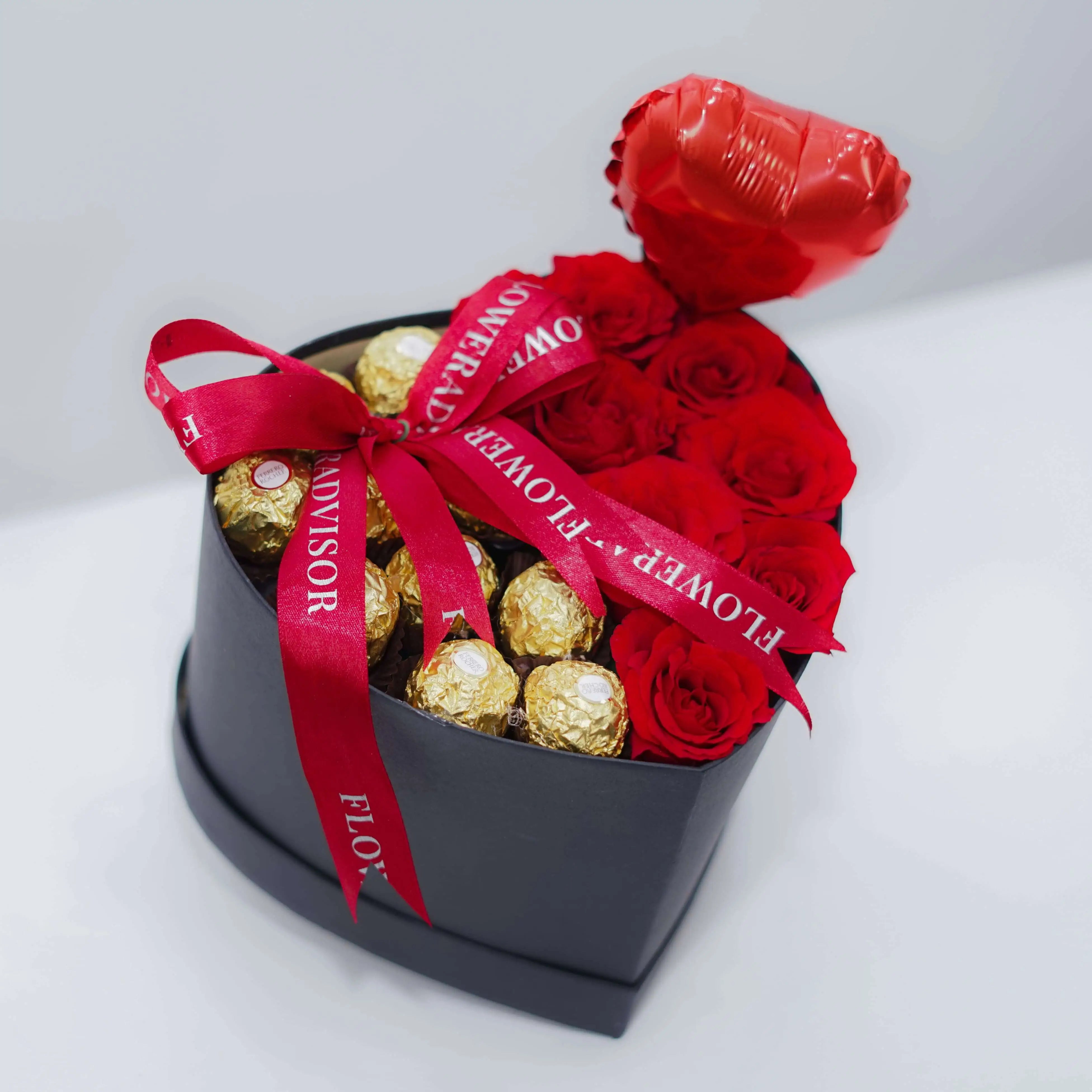 Heart-shaped flower delivery box with red roses and chocolates, gift-ready arrangement.
