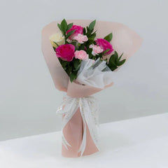 Bouquet of pink and white roses with greenery in pastel wrapping, flower delivery option