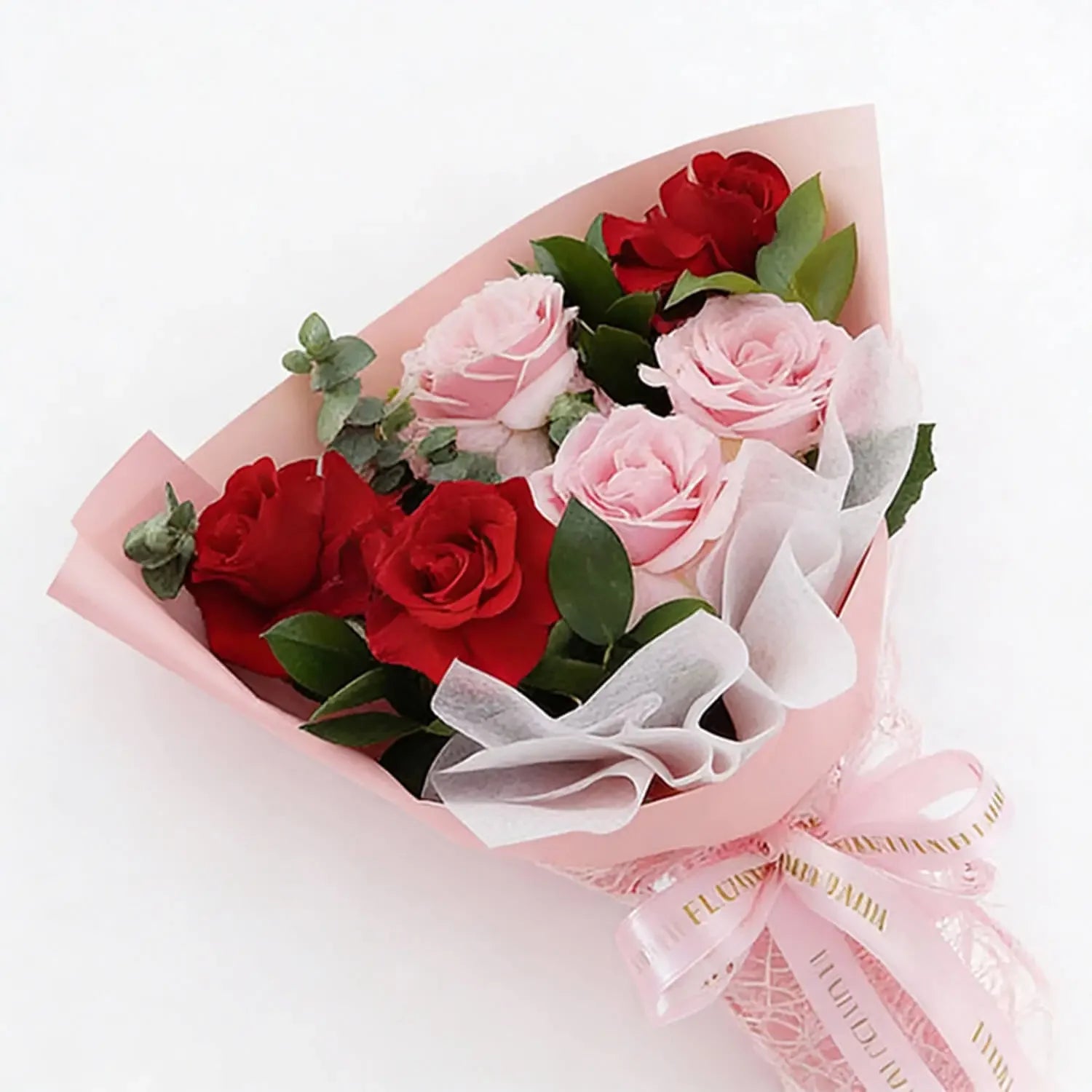 Bouquet of fresh red and pink roses wrapped in pink paper for flower delivery