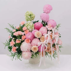 Bouquet of pink and white flowers with greenery on a white background
