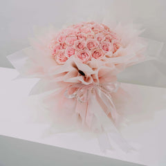 Elegant bouquet of 50 pink roses with soft wrapping, ideal for flower delivery in Singapore