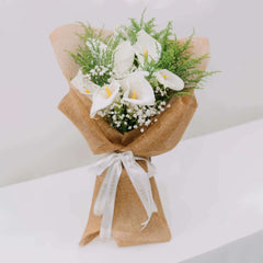 Elegant calla lily bouquet with greenery and baby's breath, ideal for flower delivery