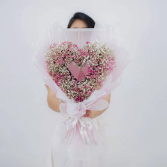 Heart-shaped pink and white baby’s breath bouquet for flower delivery, wrapped in pink ribbon
