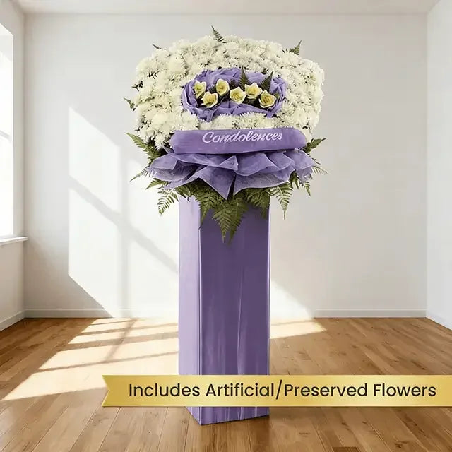 Condolence flower stand with white and yellow blooms, purple wrapping, for funeral delivery