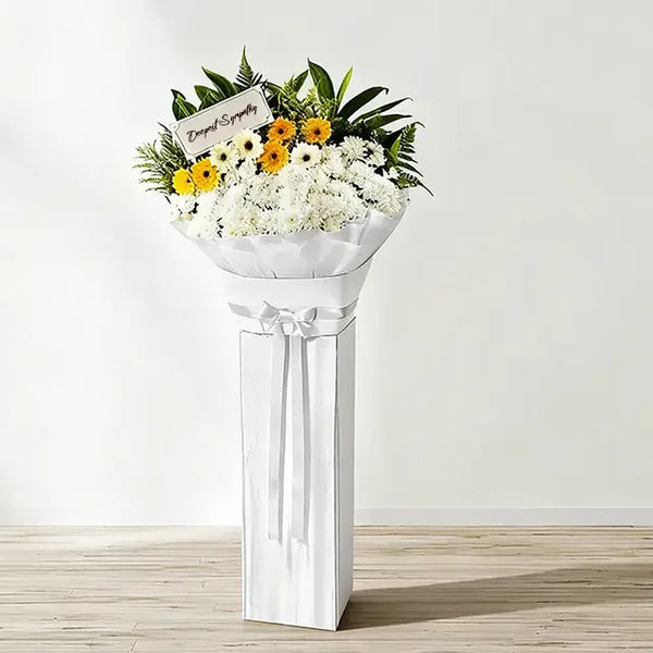 Standing flower arrangement with white and yellow blooms for condolence flower delivery